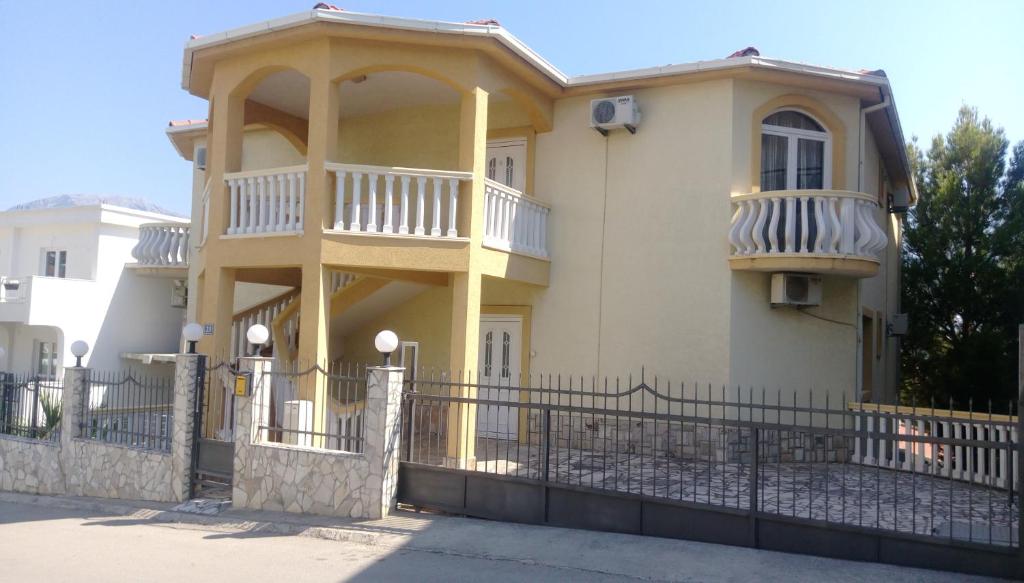 a yellow house with a fence in front of it at Apartment Barski in Bar