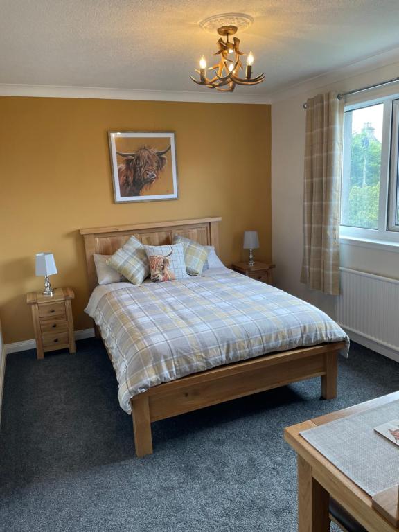 a bedroom with a bed and a chandelier at Haste Ye Back in Inverness