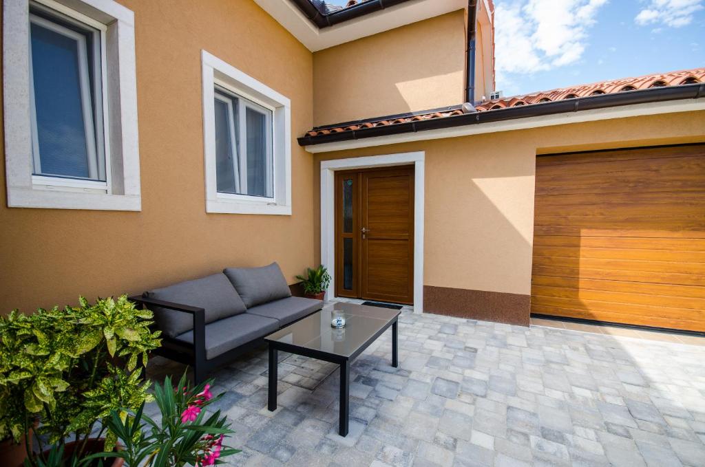 a patio with a couch and a table in front of a house at Casa Mia apartment in Vodnjan
