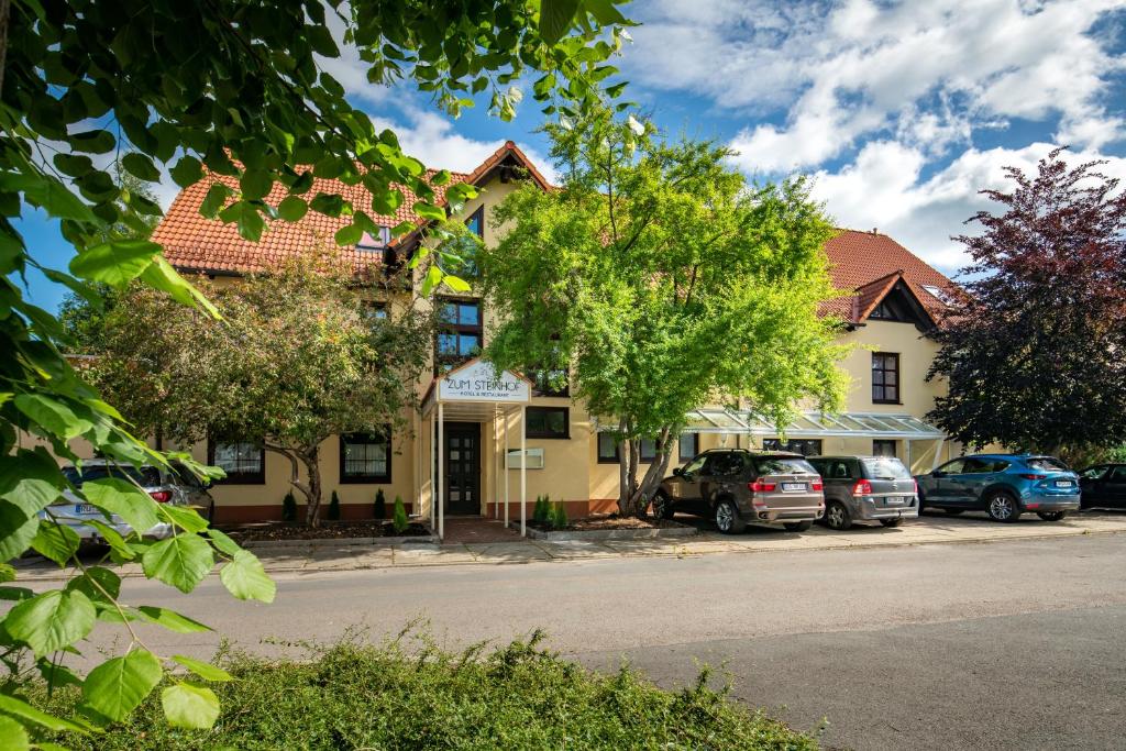 un bâtiment avec des voitures garées devant lui dans l'établissement Hotel Zum Steinhof, à Bad Blankenburg