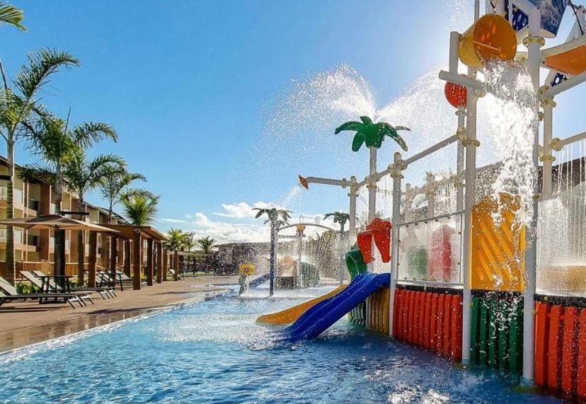 um parque aquático com escorrega e uma fonte de água em Ondas Praia Resort Apartamento em Porto Seguro