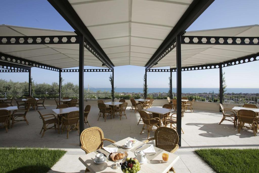 a patio with tables and chairs with a view at Villa Maria Hotel & SPA in Francavilla al Mare