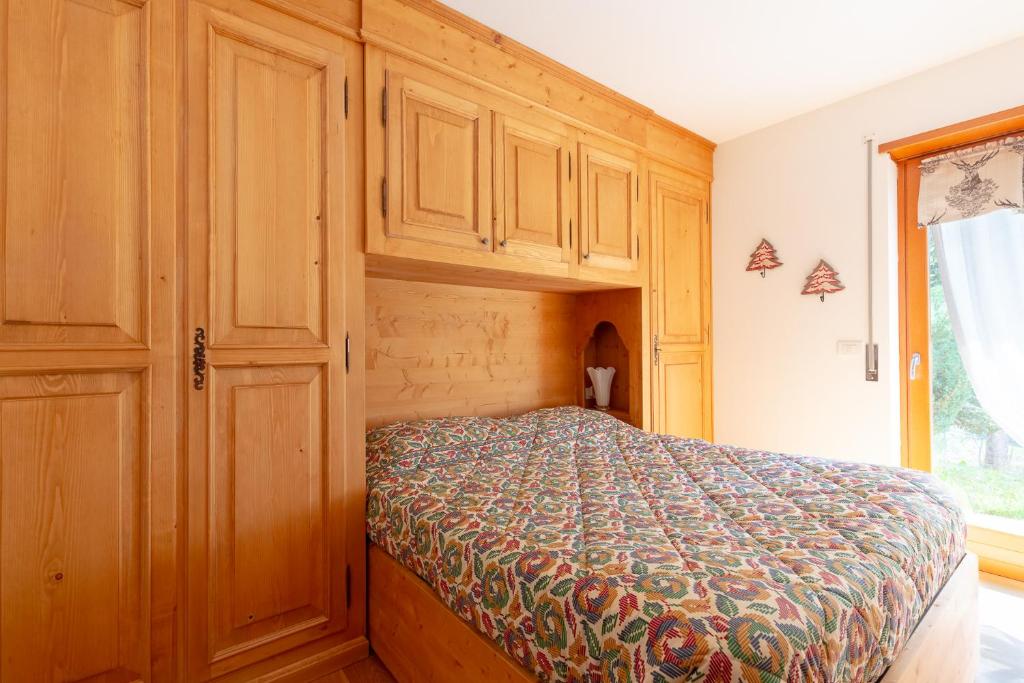 1 dormitorio con 1 cama y armarios de madera en Antico brolo Mountain lodge en Gallio