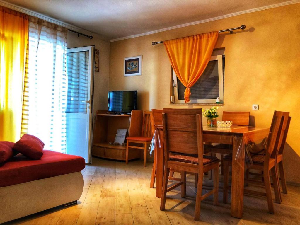 a living room with a table and a dining room at Dvosobni apartman in Banjol