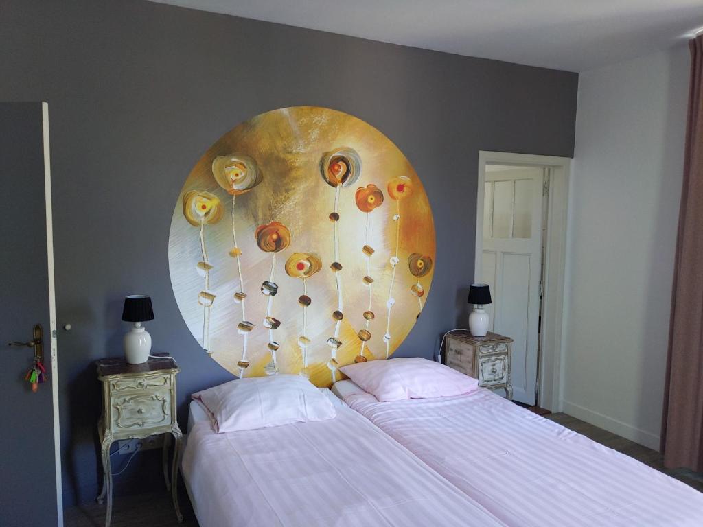 a bedroom with a bed with a large painting on the wall at Kanne&kruike in Riemst