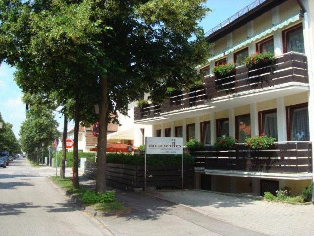 a building with balconies and a sign in front of it at Hotel Accolo in Feldkirchen
