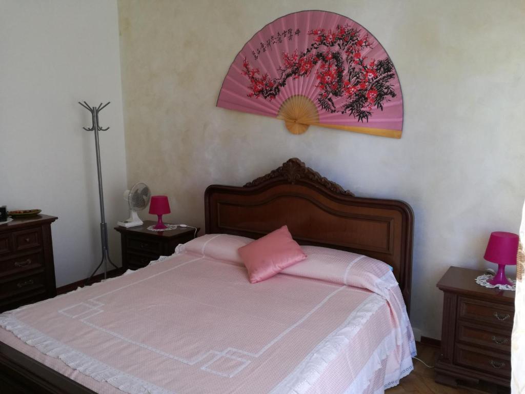 a bedroom with a large bed with a pink pillow at CASA CARBONETTO vicino alla spiaggia in Sanremo