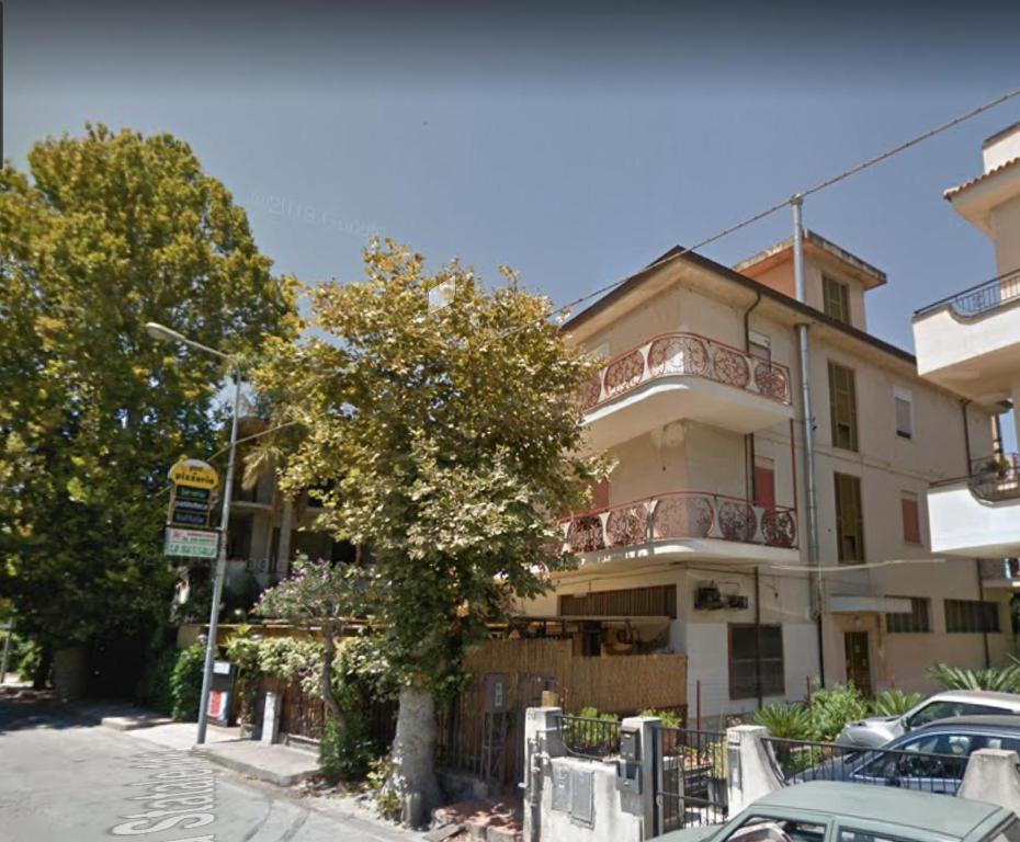 a building on a street with cars parked in front of it at Appartamento da Anna in Falcone