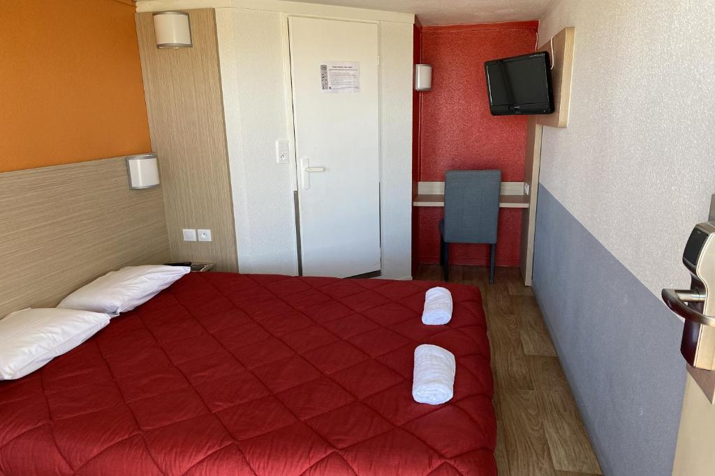 ein Hotelzimmer mit einem roten Bett und einem TV in der Unterkunft Premiere Classe Cambrai Proville in Cambrai