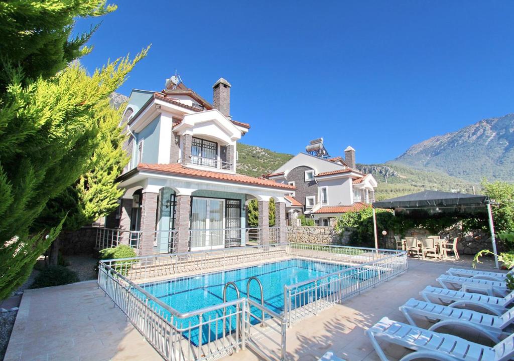 une grande maison avec une piscine en face de celle-ci dans l'établissement Villa Arnna 5 in Oludeniz, Private Pool, 4 Bedroom,, à Fethiye