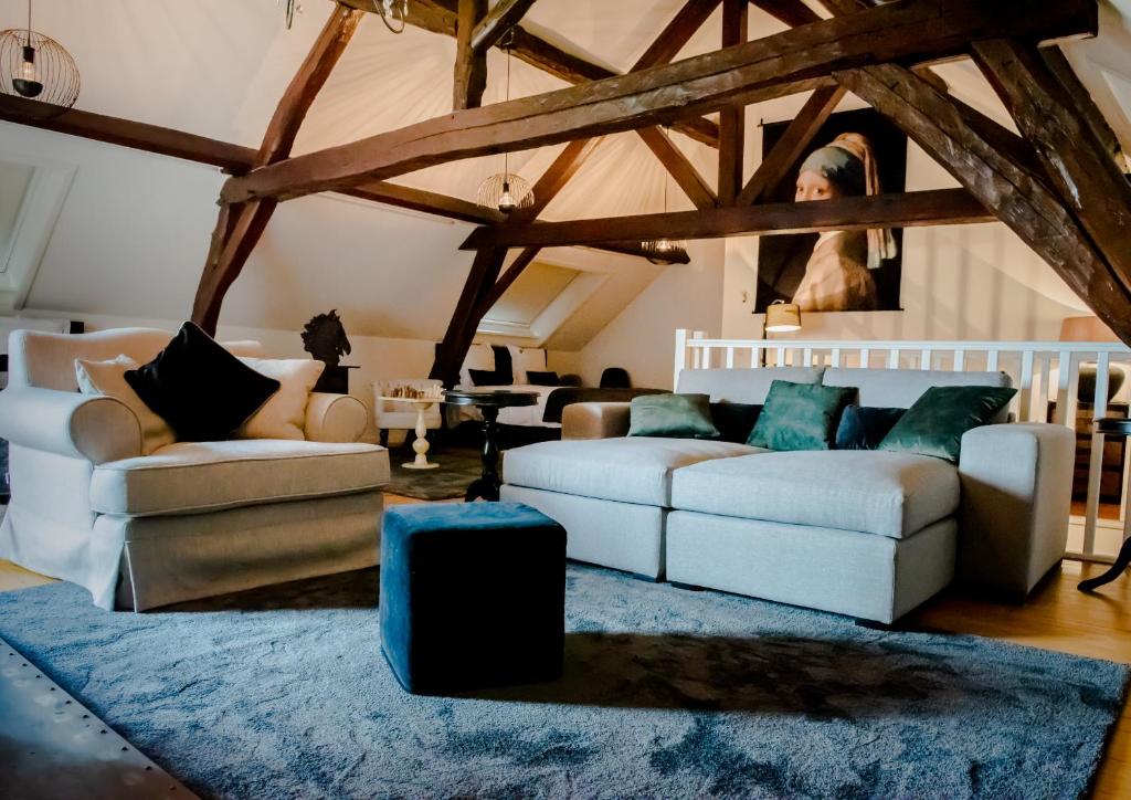 una sala de estar con 2 sofás y una alfombra azul en Huis Bertem, en Bertem