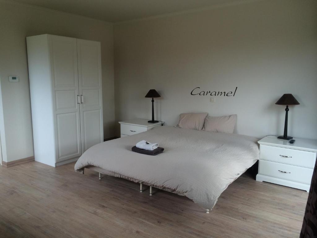una camera con un letto e due cassettiere e due lampade di B&B Caramel a Turnhout