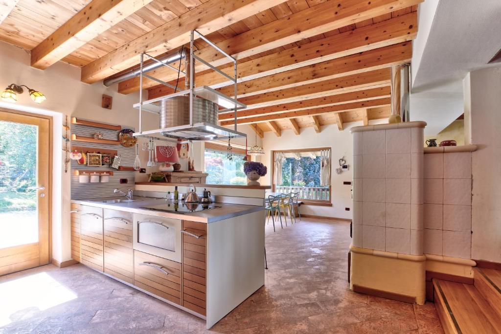 a large kitchen with wooden ceilings and wooden counters at chalet con piscina e vista panoramica in Colico