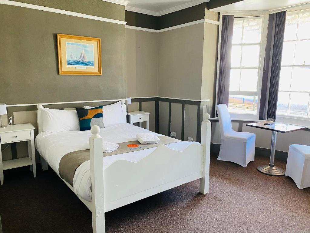 a bedroom with a white bed and a chair at Horizon in Brighton & Hove