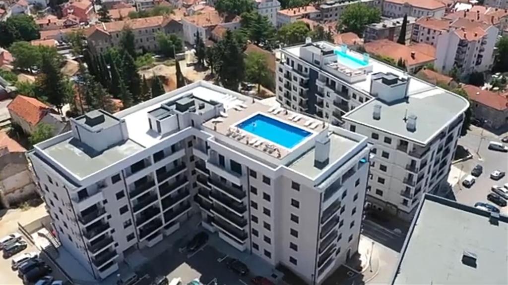 - une vue aérienne sur un bâtiment avec une piscine dans l'établissement Apartman CENTAR NEVA, à Trebinje