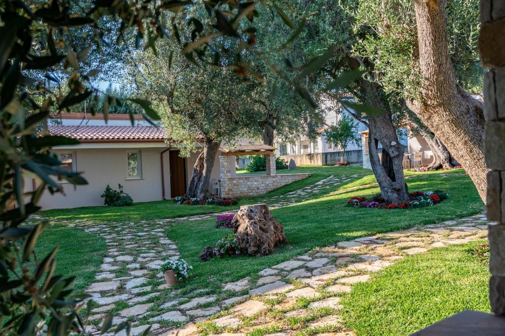 a stone path in front of a house with trees at Il Mirto Residence in Marina di Camerota