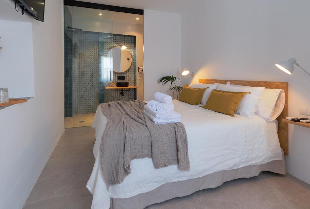 - une chambre avec un grand lit et une serviette dans l'établissement Hospedería Boutique Albariza by La Judería De Vejer- ADULTS ONLY, à Vejer de la Frontera