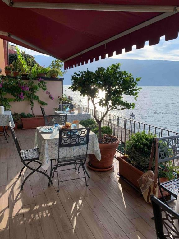 a patio with a table and chairs and the ocean at Hotel Garnì Bartabel in Gargnano