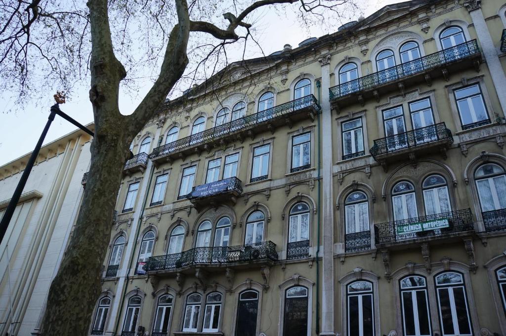 un grand bâtiment avec un arbre devant dans l'établissement Sincerely Lisboa, à Lisbonne