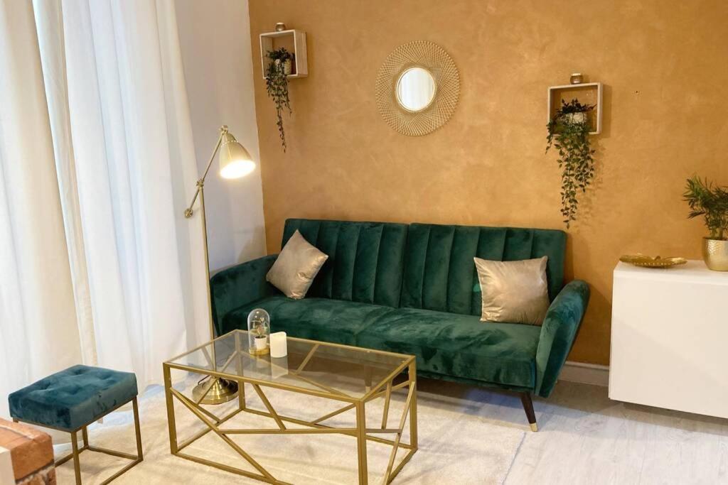 - un salon avec un canapé vert et une table dans l'établissement Studio COSY et confortable aux PORTES DE PARIS!, à Saint-Denis