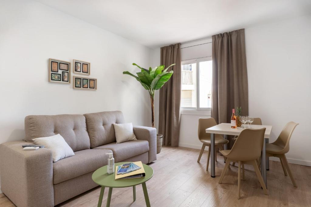 a living room with a couch and a table at Apartamentos Venecia in Lloret de Mar