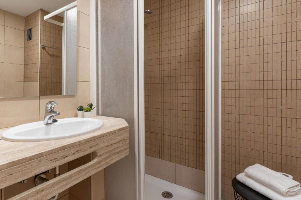 a bathroom with a sink and a shower at Apartamentos Venecia in Lloret de Mar
