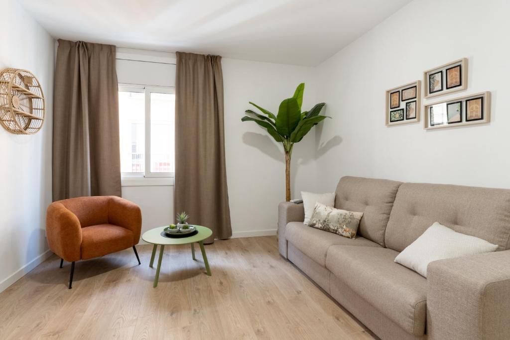 a living room with a couch and a chair at Apartamentos Venecia in Lloret de Mar