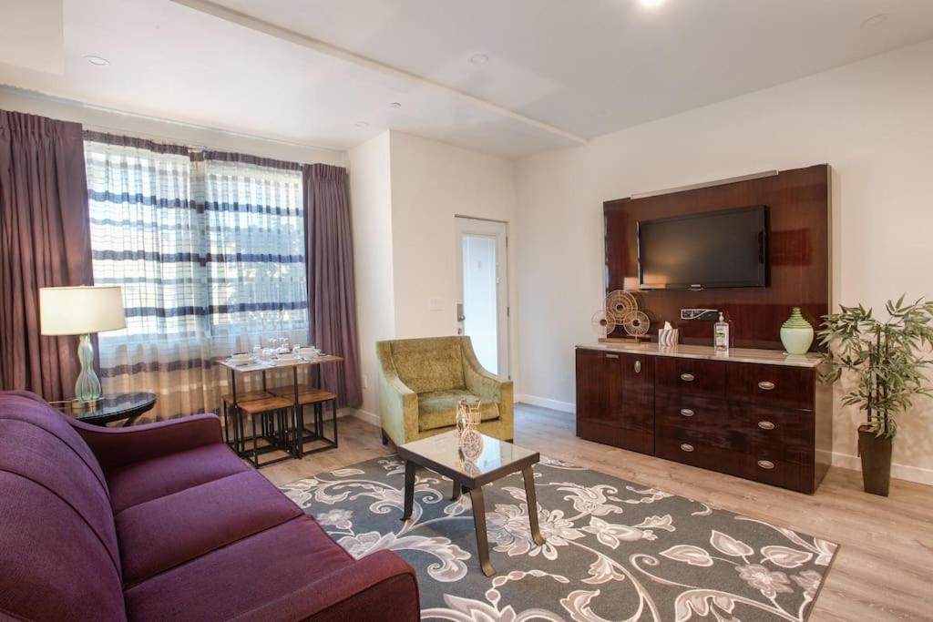 a living room with a purple couch and a tv at 1-Bedroom with Cali King Size Bed in San Diego in San Diego