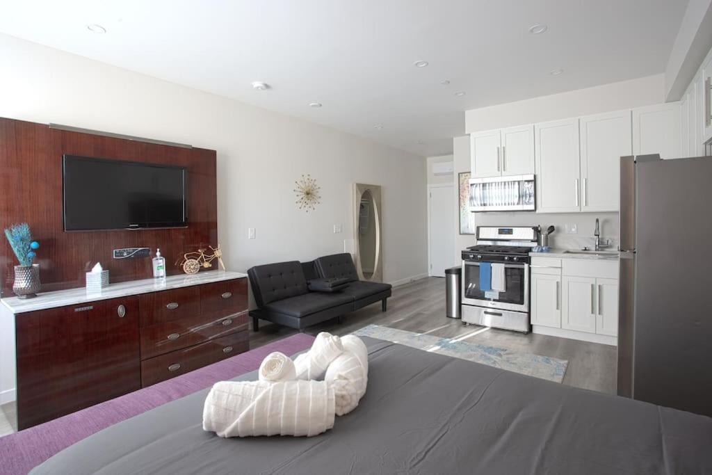 Una sala de estar con un sofá y una cocina. en Luxurious Furnished Studio w Full Kitchen in SD, en San Diego