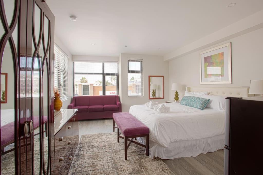 Un dormitorio con una cama grande y un sofá púrpura. en Downtown View 4 Sleepers Studio- Great for Getaway, en San Diego
