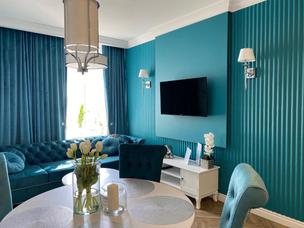 een blauwe woonkamer met een bank en een tafel bij Family & Business Sauna Apartments Sienkiewicza Wesoła No3 - No4 Centrum Downtown - 1-2 Bedroom with Private Sauna, Parking in Kielce