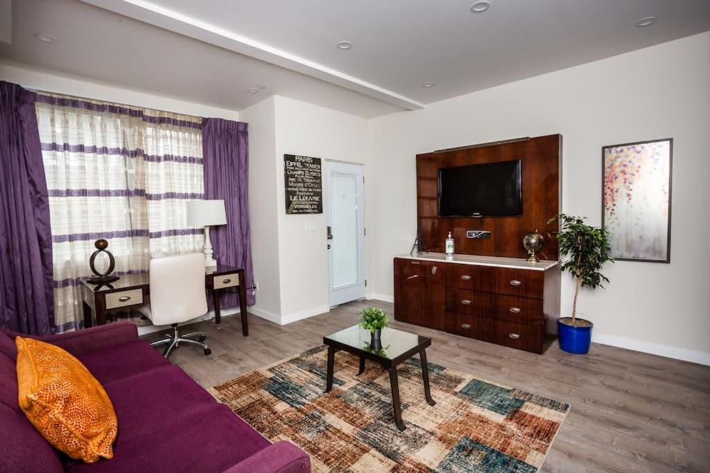 a living room with a purple couch and a tv at 1 Bedroom Apartment with Luxurious Design in SD in San Diego
