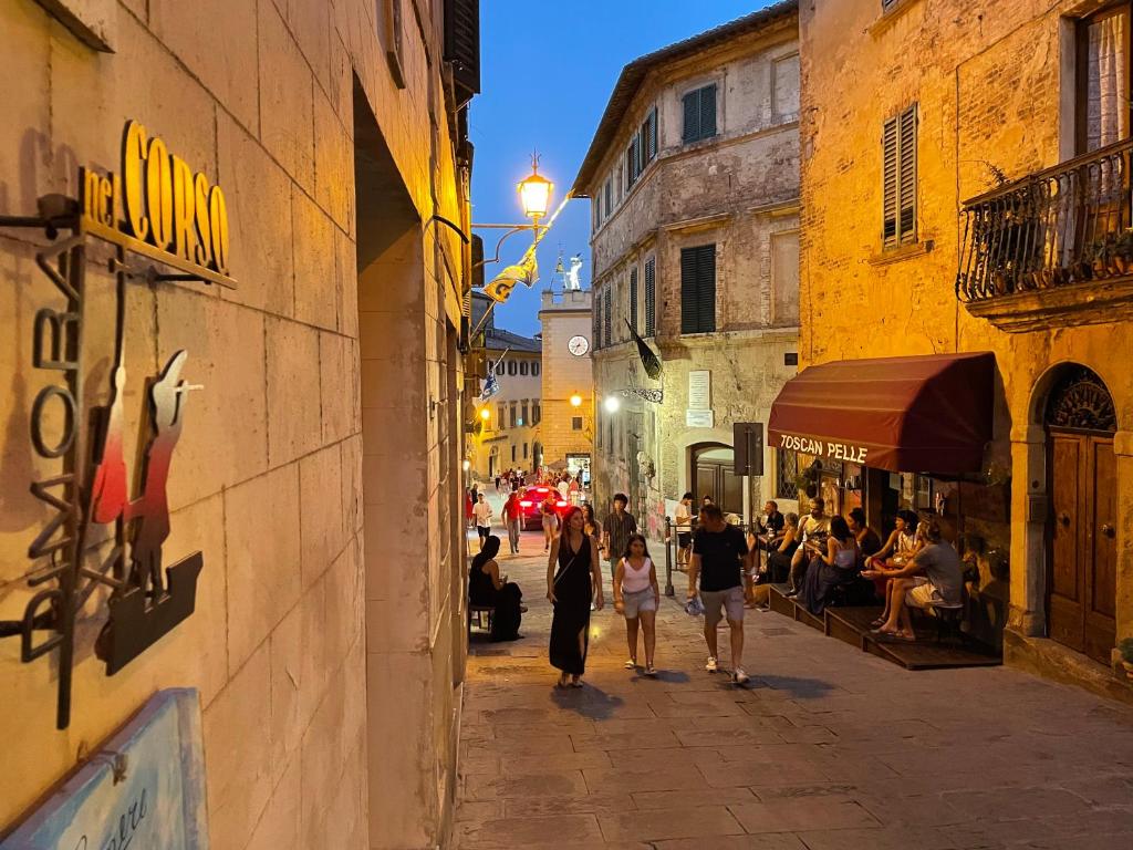 a group of people walking down a street at night at La Dimora nel Corso in Montepulciano