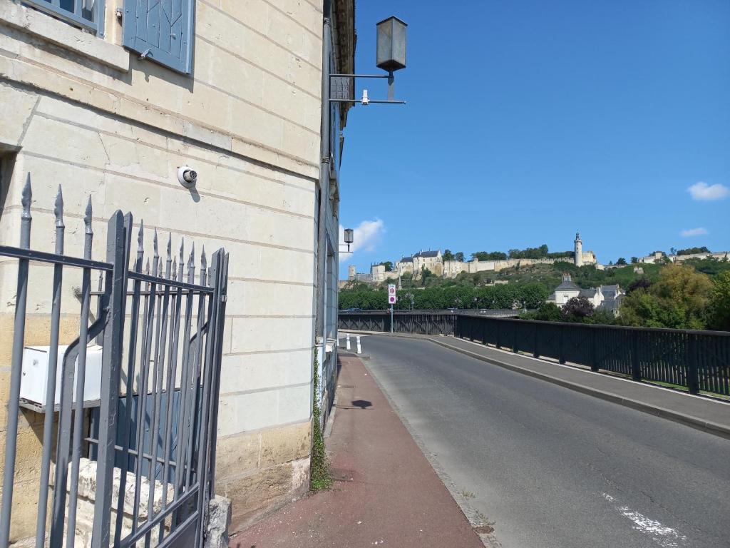 a fence on the side of a building next to a road at Agréable maison de ville au coeur de Chinon in Chinon
