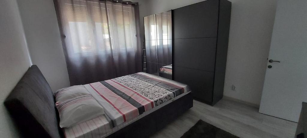 Dormitorio pequeño con cama y vestidor en Mario apartment en Strumica
