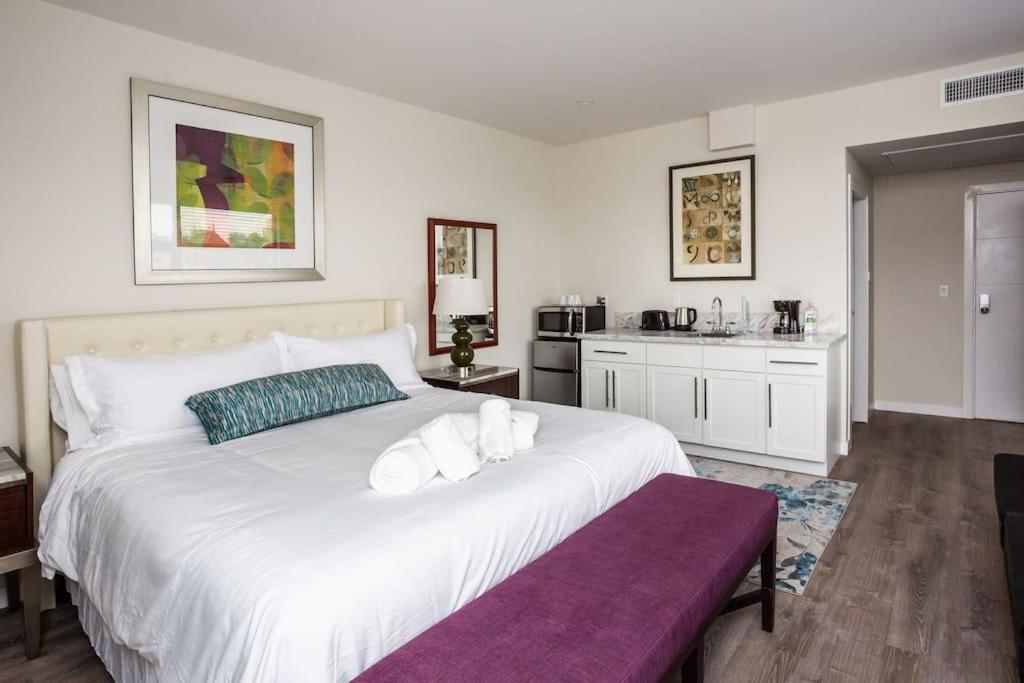 a bedroom with a large white bed and a kitchen at Modern, Luxurious and Prime location All in One in San Diego