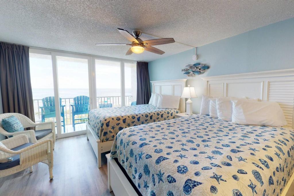 een slaapkamer met 2 bedden en een plafondventilator bij 319 - Island Inn in St Pete Beach