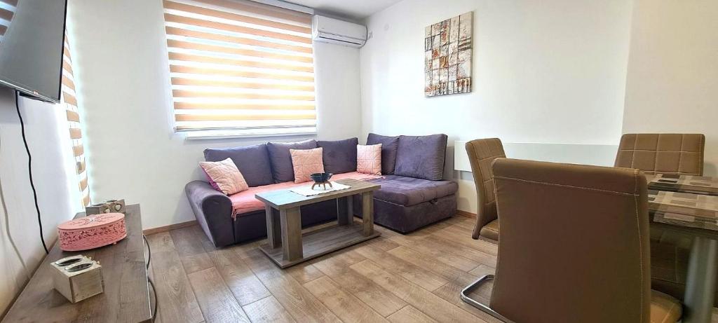 sala de estar con sofá púrpura y mesa en Apartmani Lavanda en Soko Banja