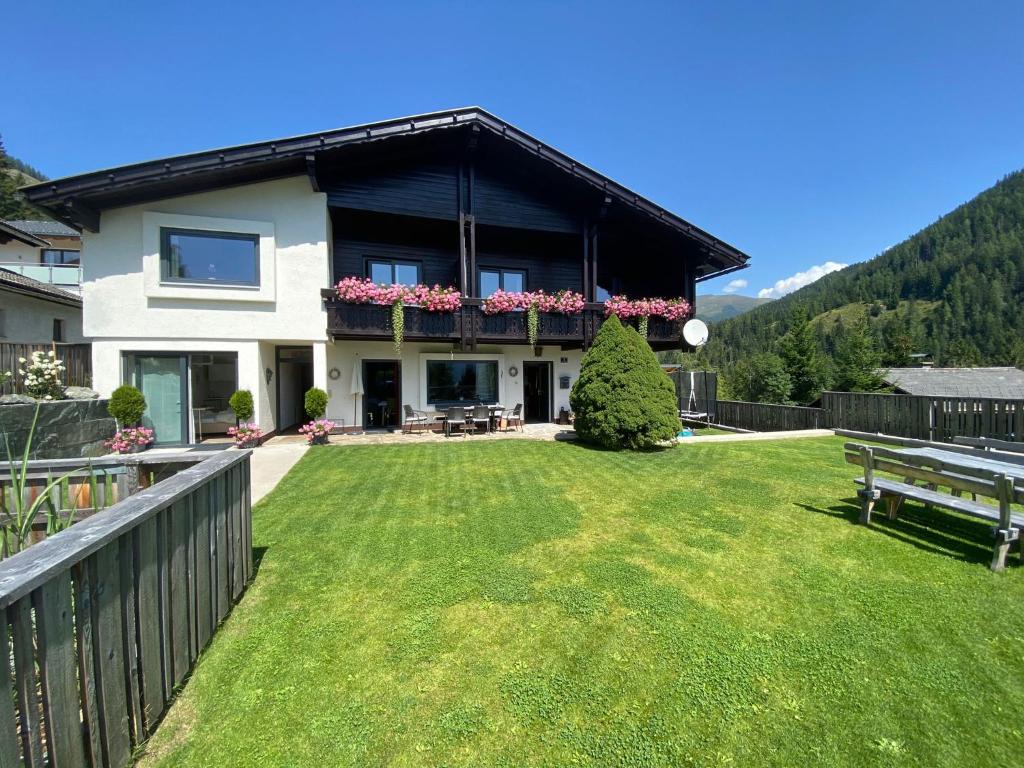 ein Haus mit einem großen Garten mit grünem Gras in der Unterkunft Appartement Latschen - Ferienhaus in Bad Kleinkirchheim