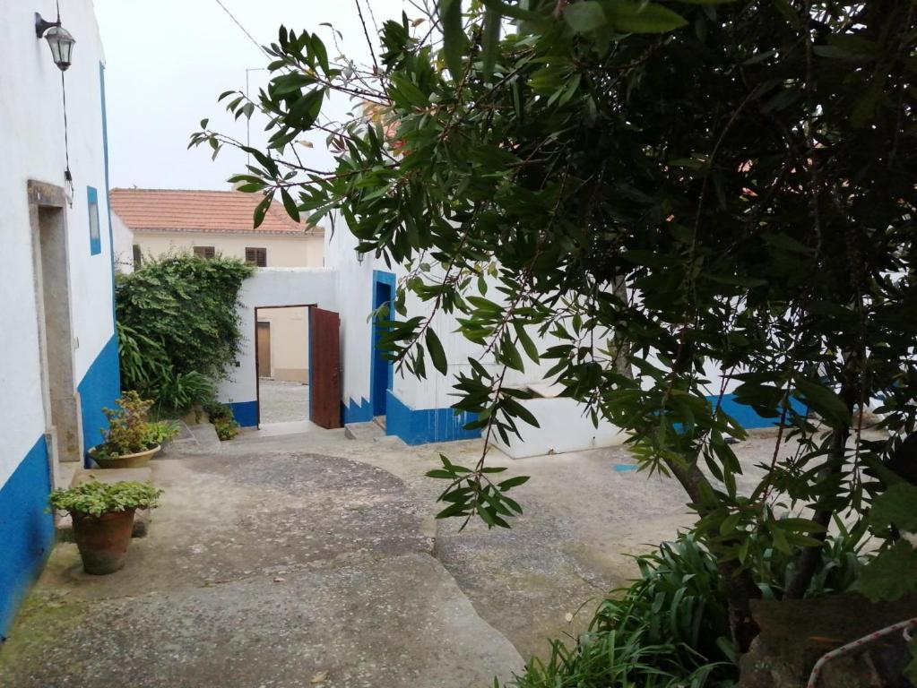 a building with blue and white walls and a courtyard at Casas Altas Obidos - AL in Sobral