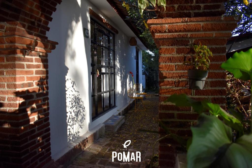 een stenen huis met een raam en een stenen muur bij Finca del Pomar in Acatlán