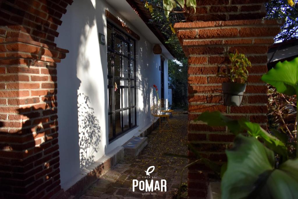 une maison en briques avec une fenêtre et un mur en briques dans l'établissement Finca del Pomar, à Acatlán
