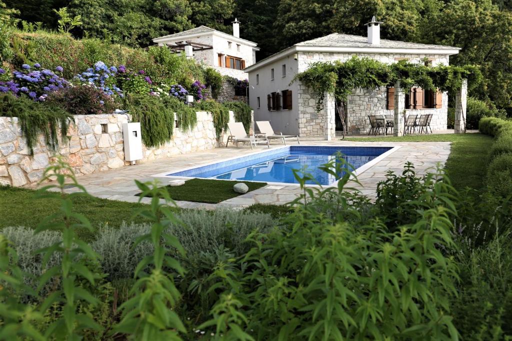 a swimming pool in a yard next to a house at Kastania Villas- Villa K3 in Pouríon