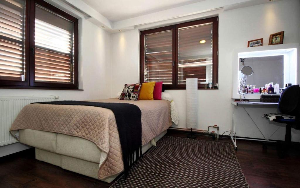 Un dormitorio con una cama, un espejo y ventanas. en Apartment Casa Sarajevo, en Sarajevo