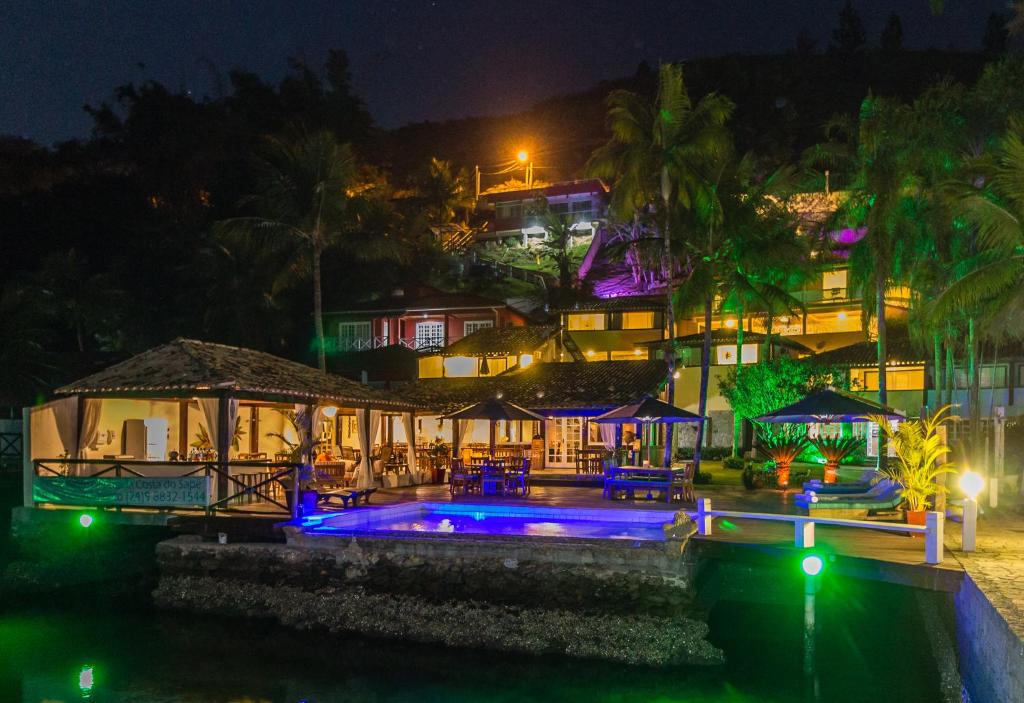 un complexe avec une piscine ouverte la nuit dans l'établissement Pousada Costa do Sapê, à Angra dos Reis