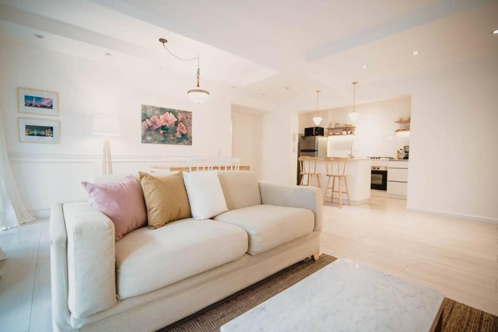 a living room with a white couch and a kitchen at Recoleta White Home in Buenos Aires
