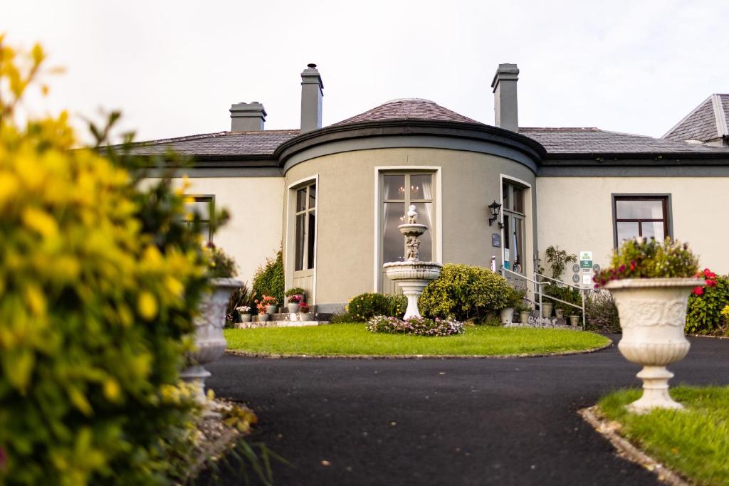 uma casa com uma entrada em frente em Ballinalacken Castle Country House Hotel em Doolin