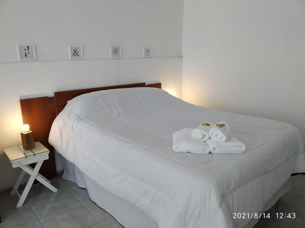 1 dormitorio con 1 cama con toallas en ETXEA Alojamiento en Deán Funes