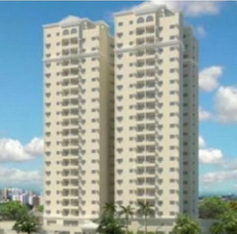 two tall white buildings with trees in front of them at Apto 3 Quartos com Ar, Piscina, Garagem - Cuiabá in Cuiabá