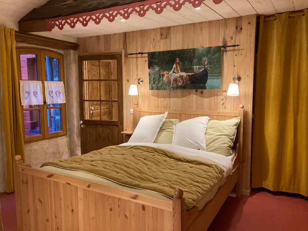 1 dormitorio con 1 cama grande y pared de madera en La cour secrète, en Dinan